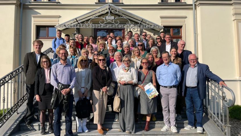 Grupa ludzi pozująca na schodach do zdjęcia
